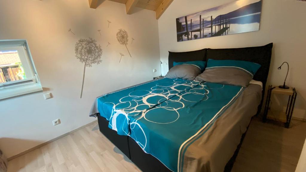 a bedroom with a bed with a blue comforter at KWO-villa Sonnenglück in Arnoldstein