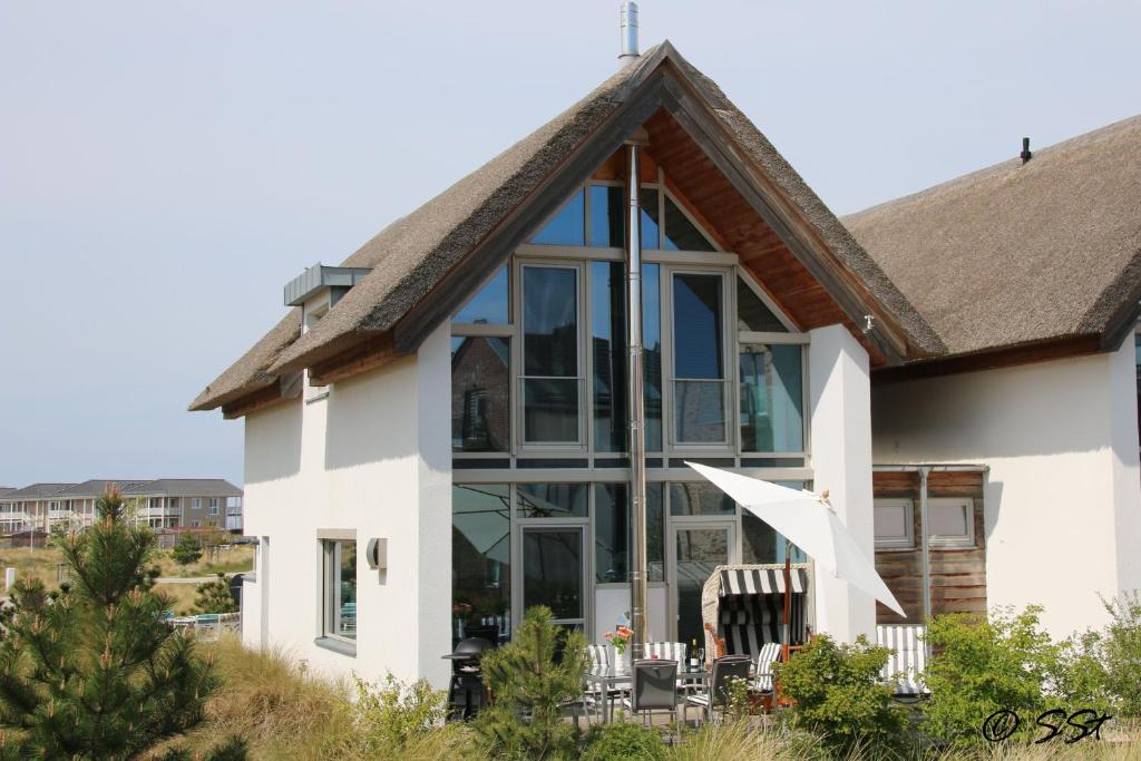 ein Haus mit großen Fenstern und einem Dach in der Unterkunft Ostsee - Reetdachhaus Nr 9 "Emma" im Strand Resort in Heiligenhafen
