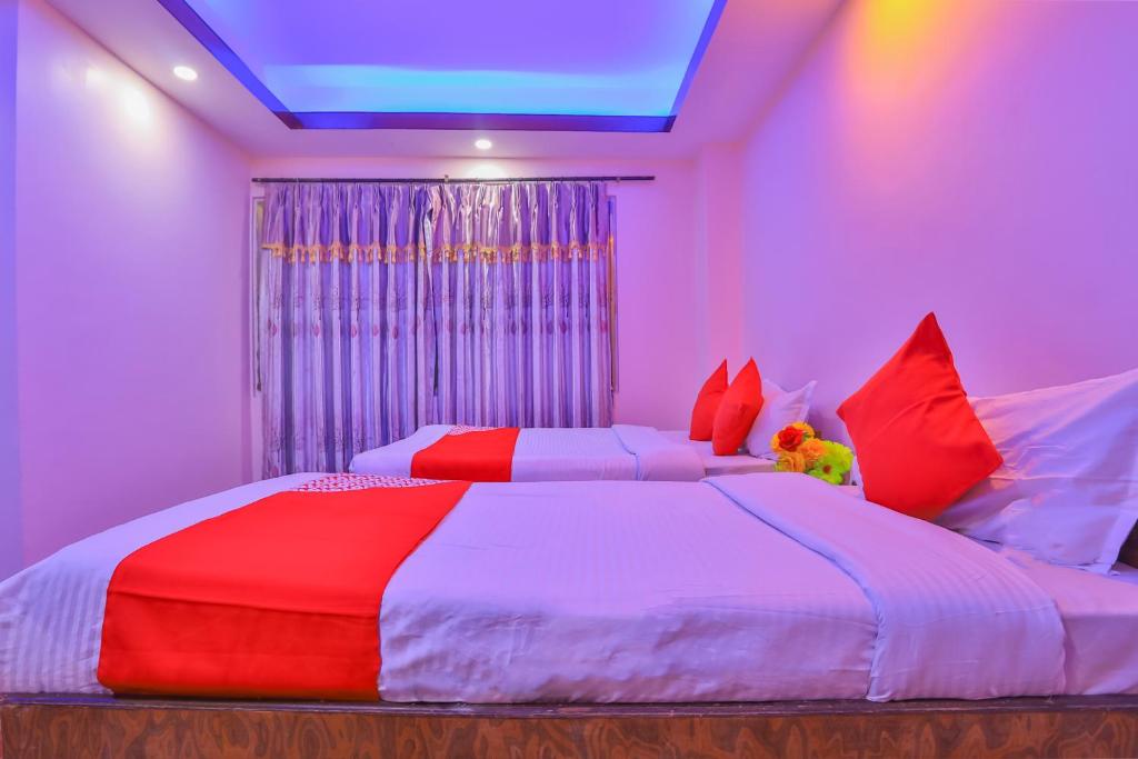 a bedroom with two beds with red and white sheets at OYO 656 Hotel Shree Guru in Kathmandu