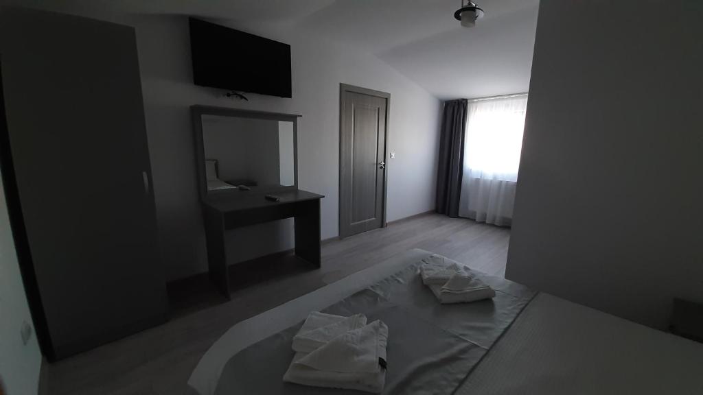 Zimmer mit einem Bett, einem Waschbecken und einem Spiegel in der Unterkunft DNK Residence in Simila