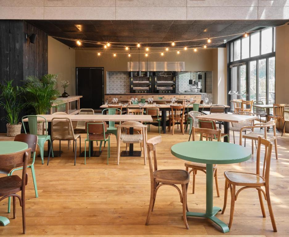 a restaurant with tables and chairs and a kitchen at BERCAIL in Wambrechies