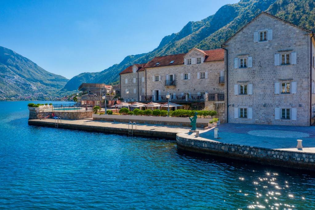 a group of buildings next to a body of water at Hotel Splendido in Kotor