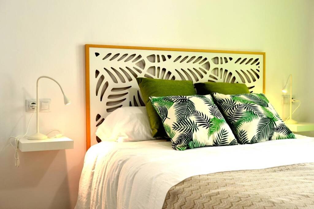 Una cama con almohadas verdes y blancas. en Monachil Apartamento La Vereda recién estrenado, en Monachil