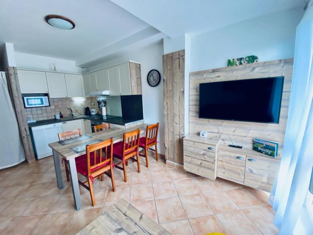 a kitchen with a table and chairs and a television at Apartmán u Vlka in Donovaly