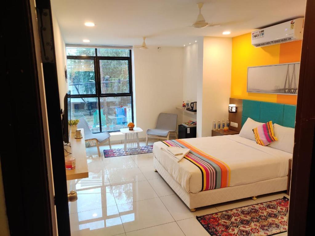 Hotel White Fields Hitec City, Hyderabad في حيدر أباد: غرفة نوم مع سرير وغرفة معيشة