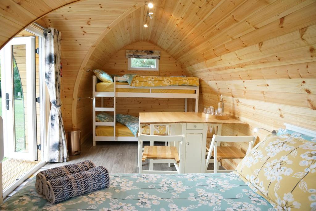a room with a bed and a desk in a tiny house at The Piggery Pod in Sittingbourne