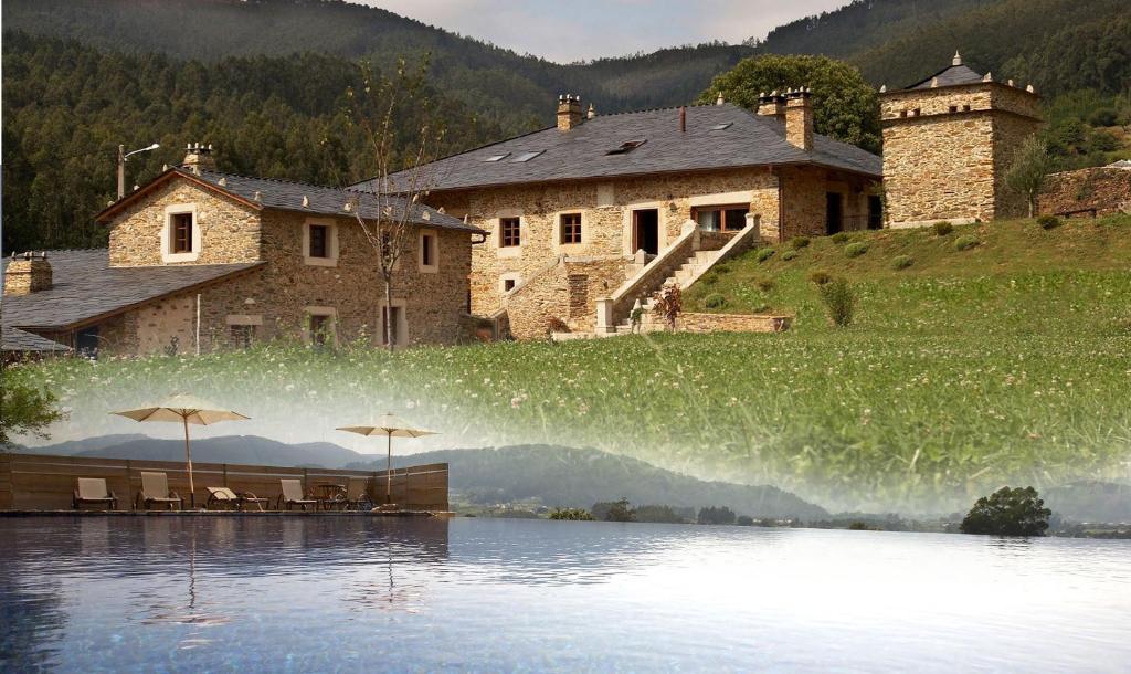 a house with a lake in front of a building at Areal in Viveiro