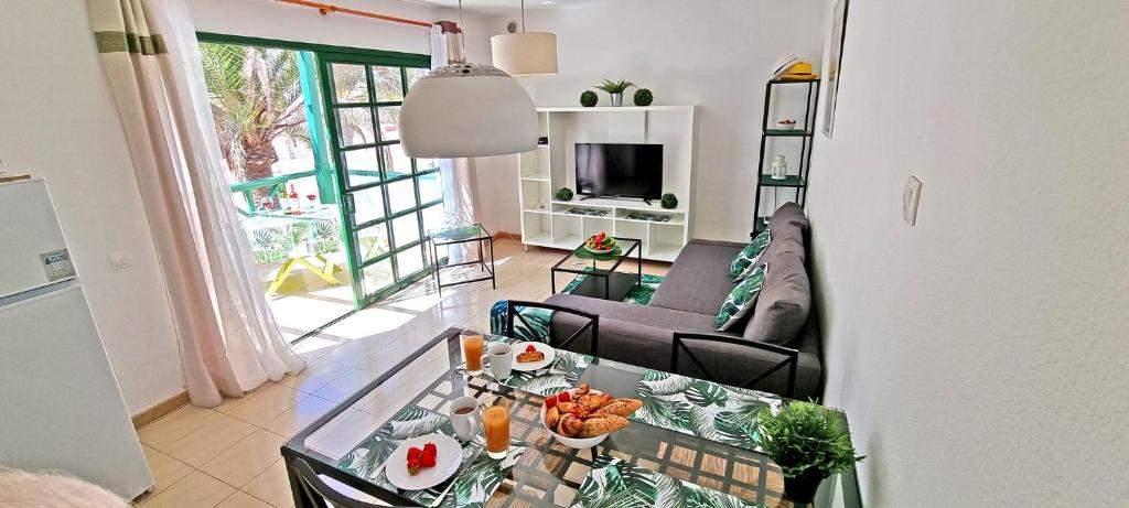 salon z kanapą i stołem w obiekcie Ferienwohnung PALM GARDEN - Costa Calma - Pool - GlasfaserInternet w mieście Costa Calma