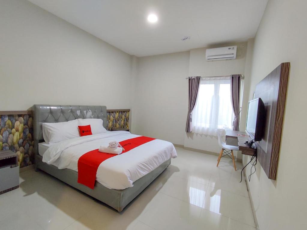 a bedroom with a bed and a television in it at RedDoorz Syariah near GOR Satria Area in Purwokerto
