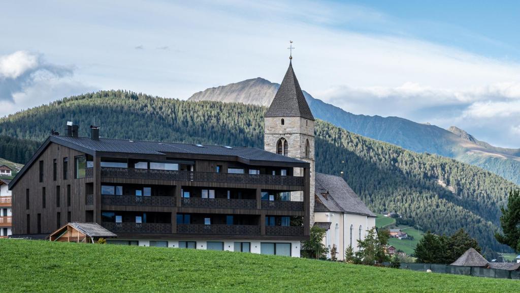 a building on top of a hill with a church at Mountain Lodge Margit in Maranza