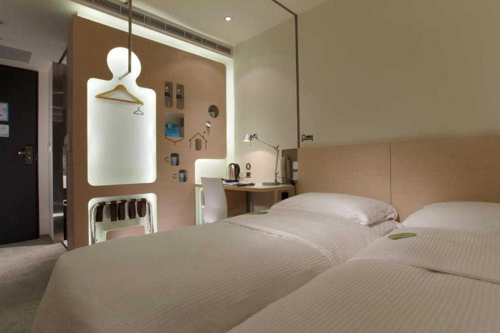 a bedroom with two white beds and a desk at Just Sleep - Lin Sen in Taipei