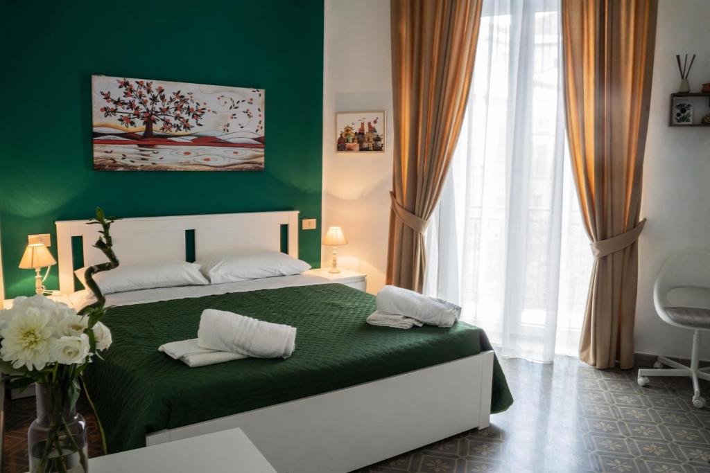 Dormitorio verde con cama y pared verde en Ai Giudici, en Palermo