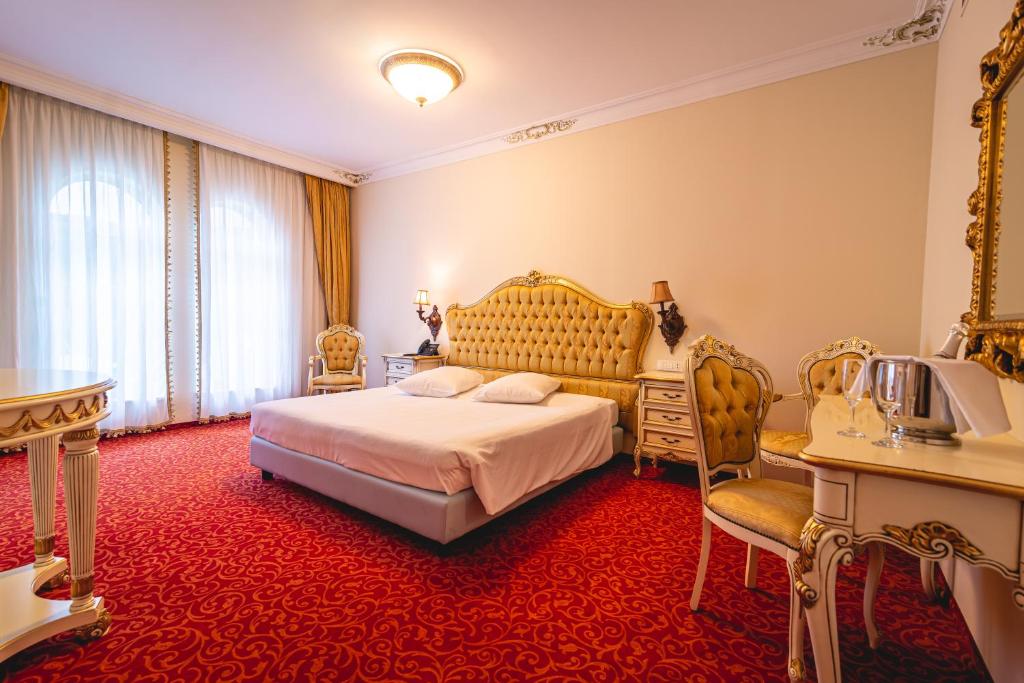 1 dormitorio con cama extragrande y alfombra roja en Casino & Hotel ADMIRAL Skofije, en Zgornje Škofije