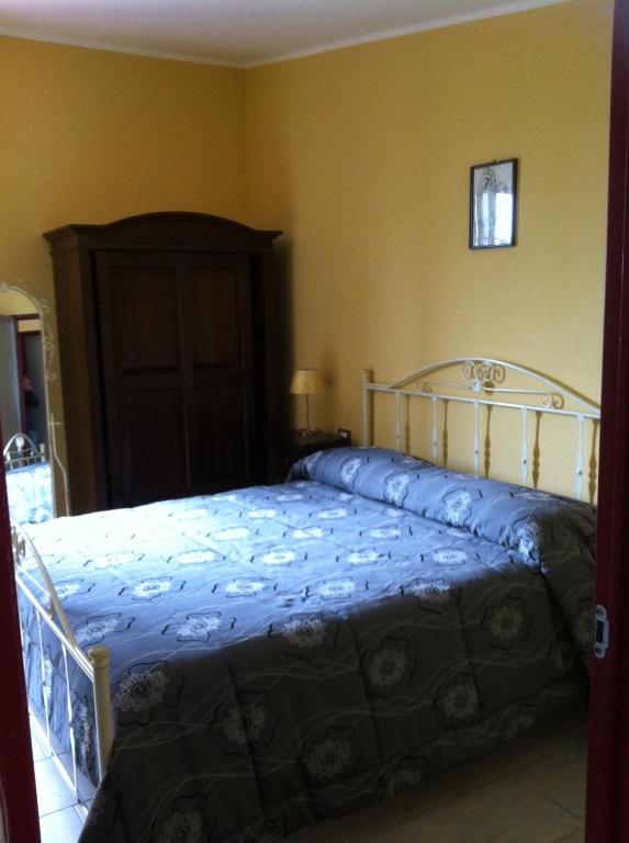 a bedroom with a bed with a blue comforter at Agriturismo Eolo in Taranto