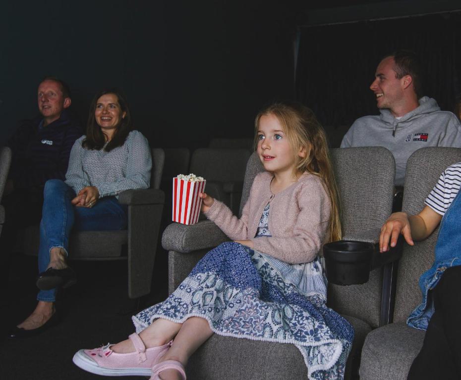 a little girl sitting in the audience holding popcorn at Esplanade Hotel in Newquay