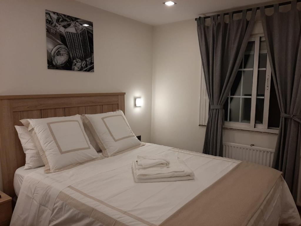 um quarto com uma cama branca com duas toalhas em Habitacion cerca del Aeropuerto em Coslada