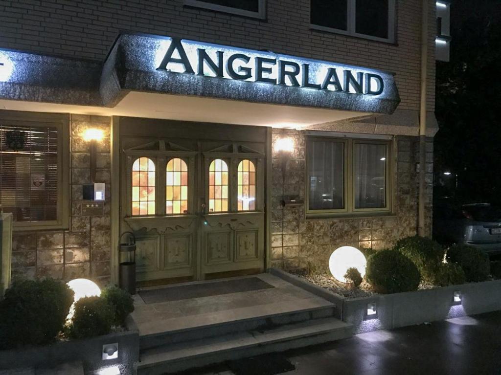 a entrance to an american restaurant at night at Hotel Angerland Garni in Ratingen