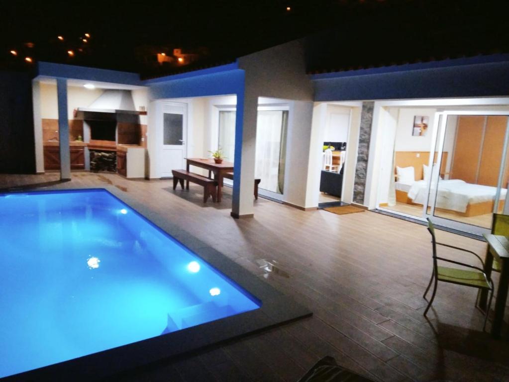 a large swimming pool in a room with a living room at CASA SOL E VISTA 2 in Arco da Calheta