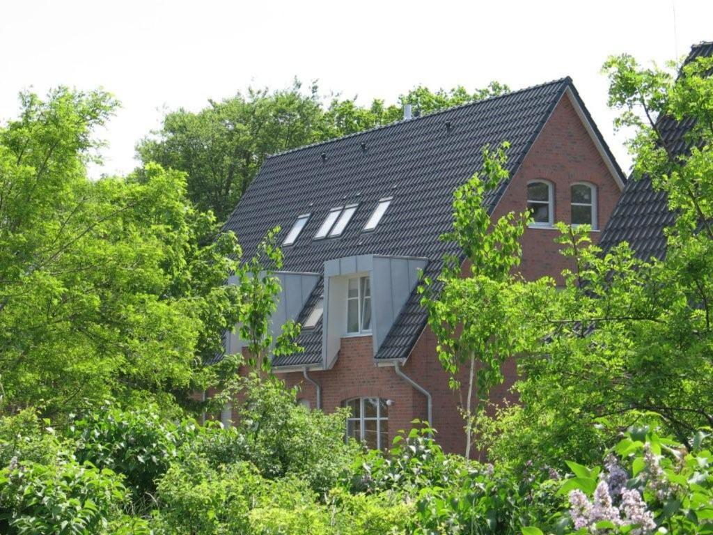 ボルテンハーゲンにある2 Zimmer Appartement Ostseeblickの赤レンガ造りの黒屋根