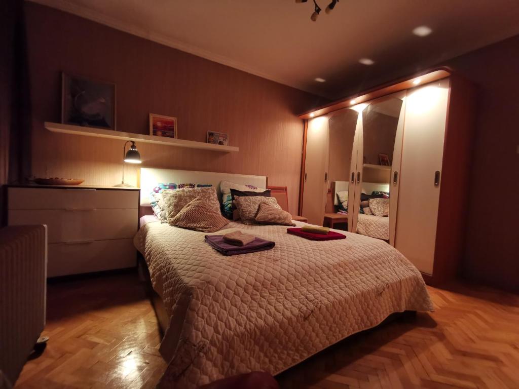 a bedroom with a large bed and a mirror at Spacious quiet apartment next to Arena Armeec and Metro station GM Dimitrov in Sofia