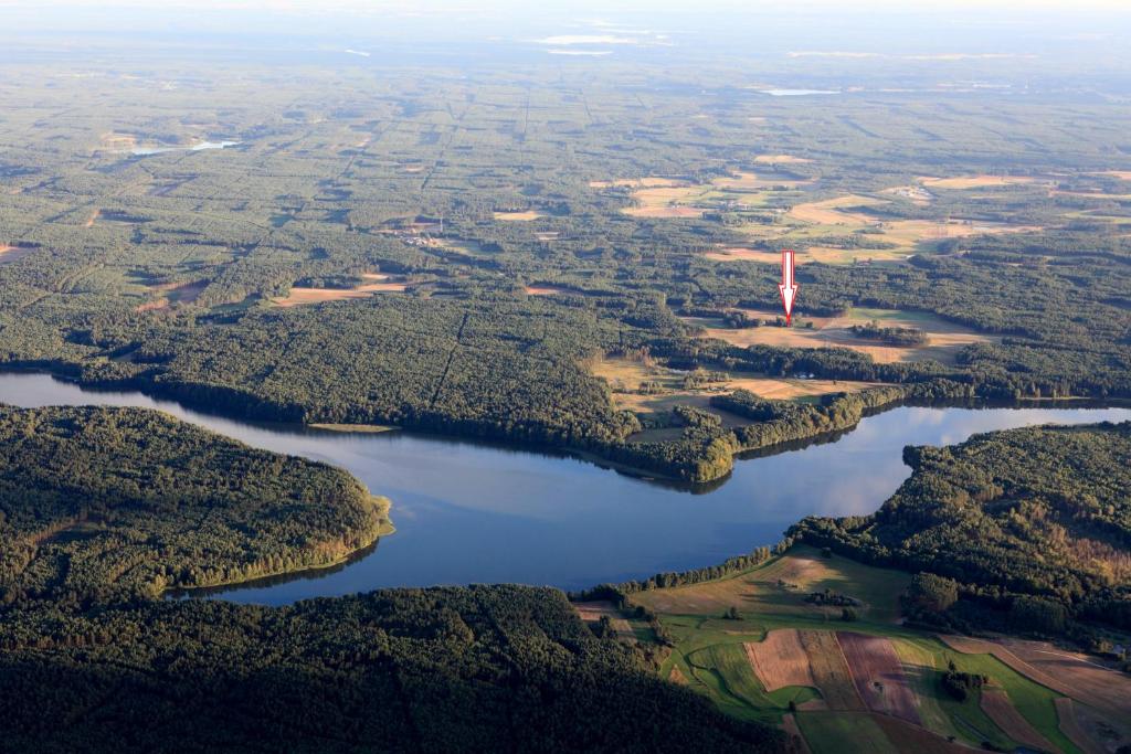 z powietrza widok na jezioro z czerwoną wieżą w obiekcie Apartament w lesie w mieście Lipnica