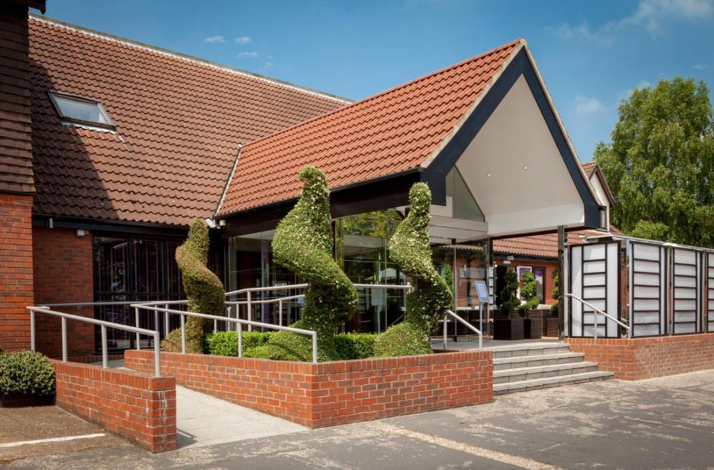 ein Gebäude mit einer Skulptur in Form von Katzen in der Unterkunft The Winchester Hotel and Spa in Winchester