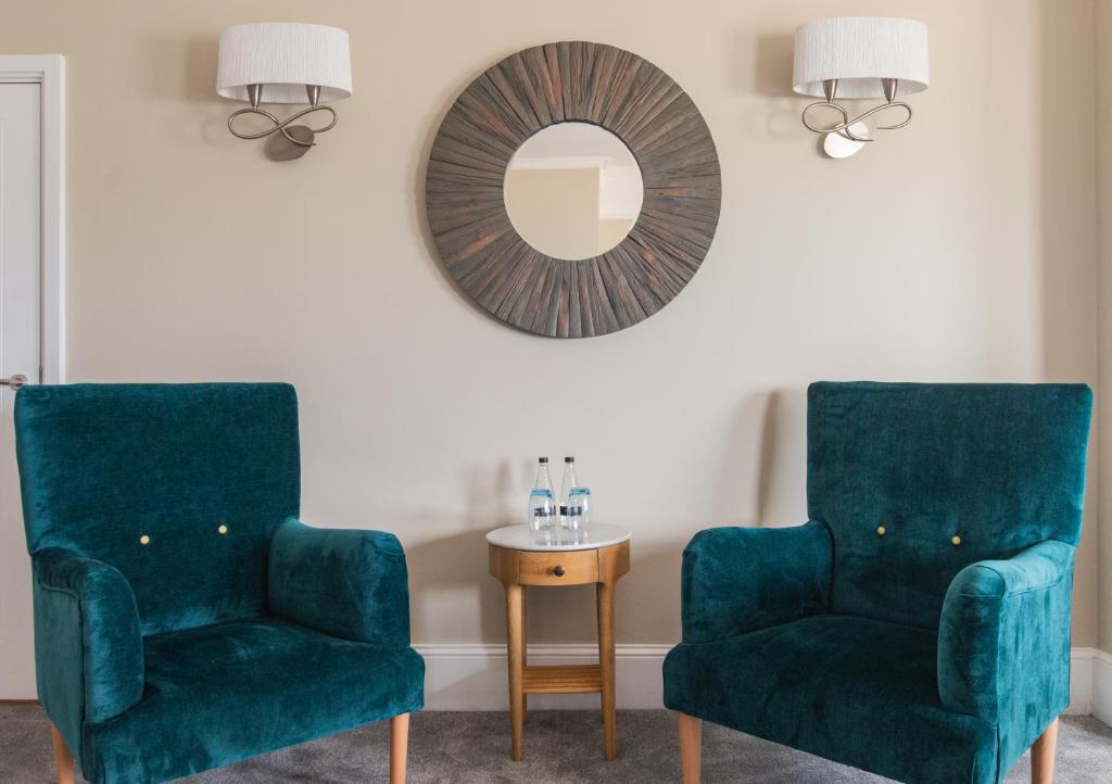 two green chairs and a mirror in a room at The Brudenell in Aldeburgh