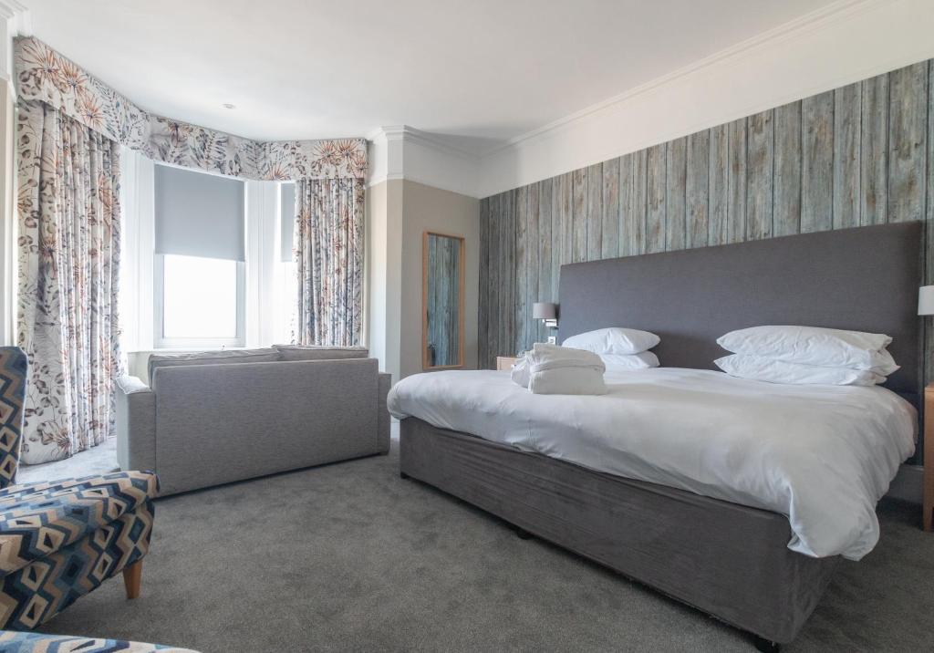 a bedroom with a large bed and a large window at The Brudenell in Aldeburgh