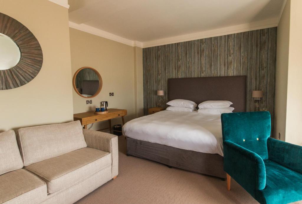 a hotel room with a bed and a chair at The Brudenell in Aldeburgh