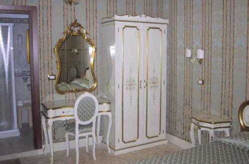 a room with a dresser and a mirror and a chair at Residenza Hotel San Maurizio in Venice