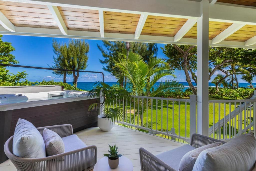 - une terrasse couverte avec des chaises et une vue sur l'océan dans l'établissement Camp Alealea 1 home, à Hanalei