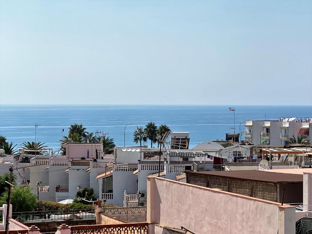 een stad met gebouwen en de oceaan op de achtergrond bij Mariposa Studio Casasol in Nerja