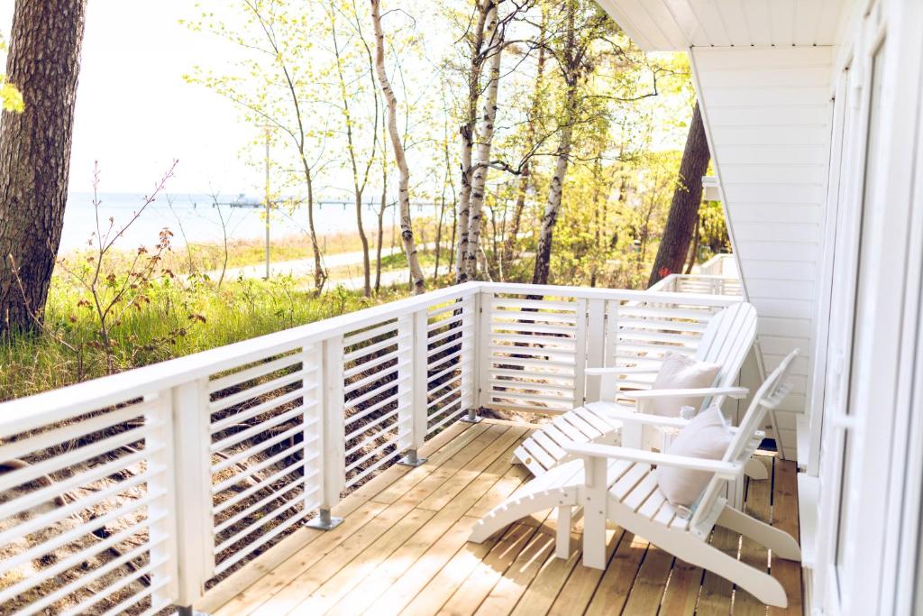 a porch with two chairs and a view of the water at Regenbogen Göhren in Göhren