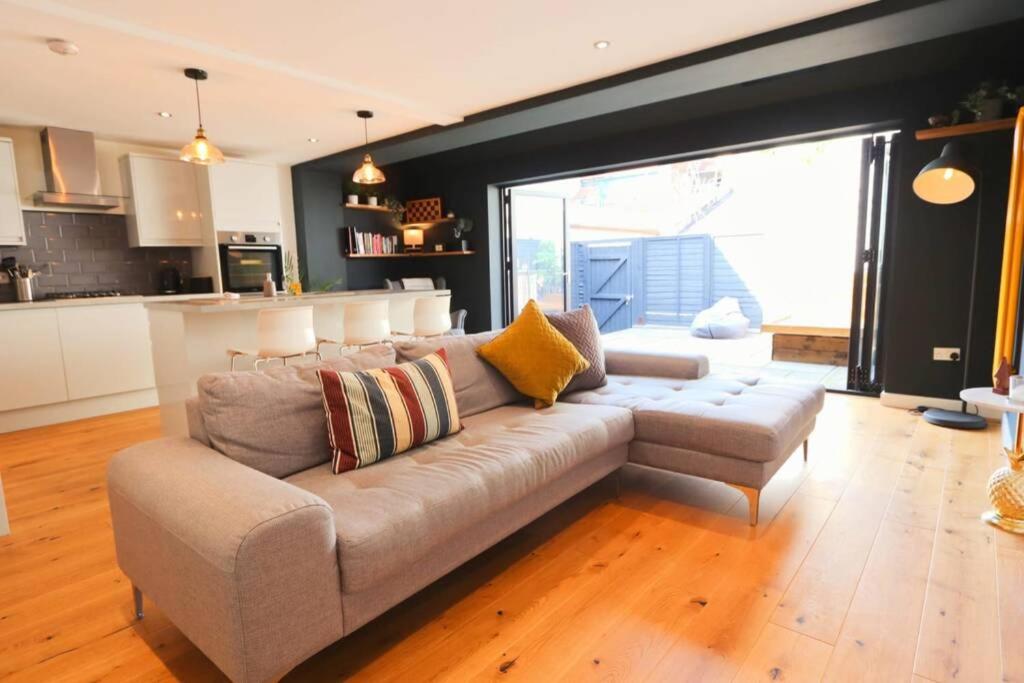 a living room with a couch and a kitchen at Hotwells Modern Mews in Bristol