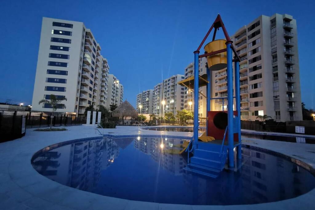 een speeltuin in het midden van een zwembad met gebouwen bij Lindo apartamento cerca a Girardot in Ricaurte