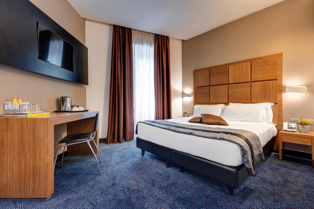 a hotel room with a bed and a desk at Rome Art Hotel - Gruppo Trevi Hotels in Rome