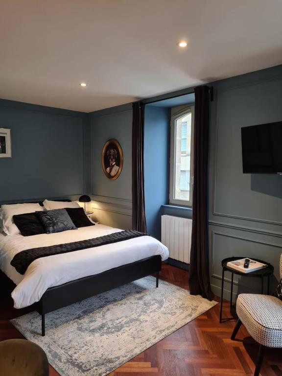 LESAGE, au coeur de Vannes في فان: غرفة نوم بجدران زرقاء وسرير بسجادة