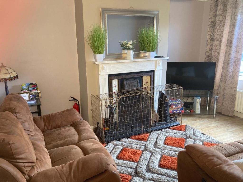 ein Wohnzimmer mit einem Sofa und einem Kamin in der Unterkunft Enniskillen House (6 person house) in Enniskillen