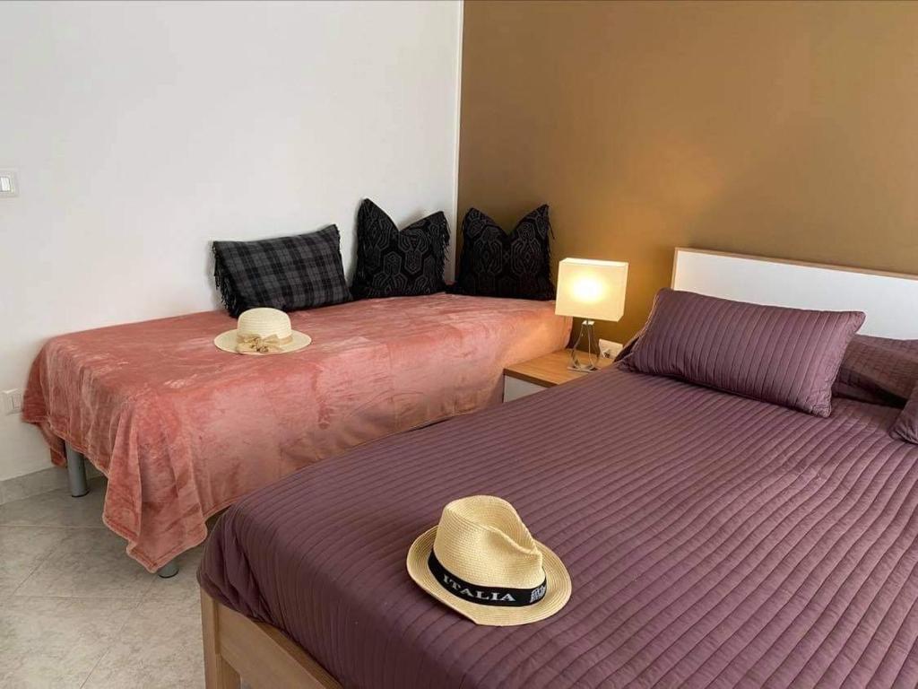 - une chambre avec 2 lits avec des chapeaux dans l'établissement casa norvegese, à Pizzo