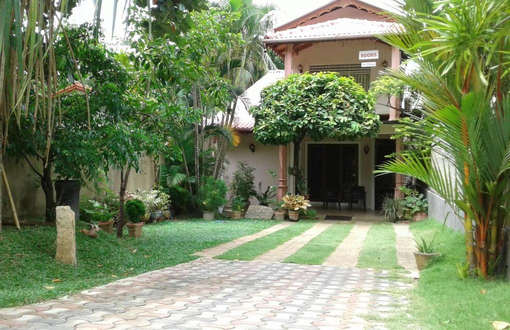 a house with a garden and a brick walkway at SA Village in Dambulla