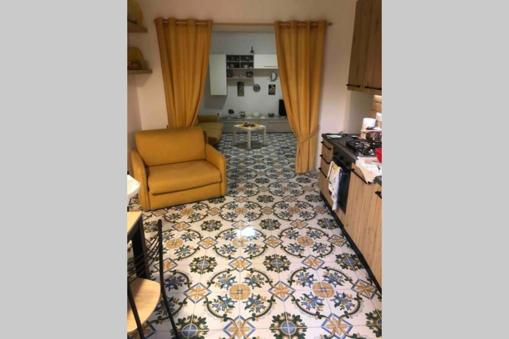 sala de estar con sofá y silla en una habitación en AffIttasi Casa Giuseppe, en Procida