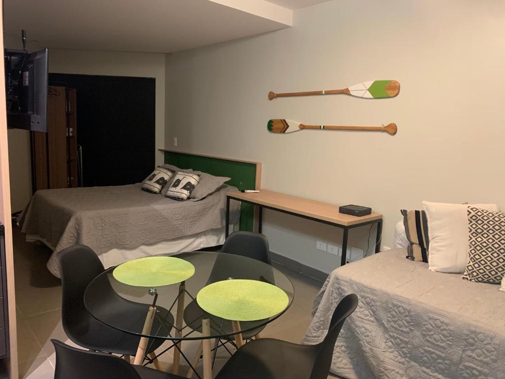 een kamer met 2 bedden en een tafel en stoelen bij Apartamento Studio na Beira Mar de Pajuçara - todo reformado in Maceió