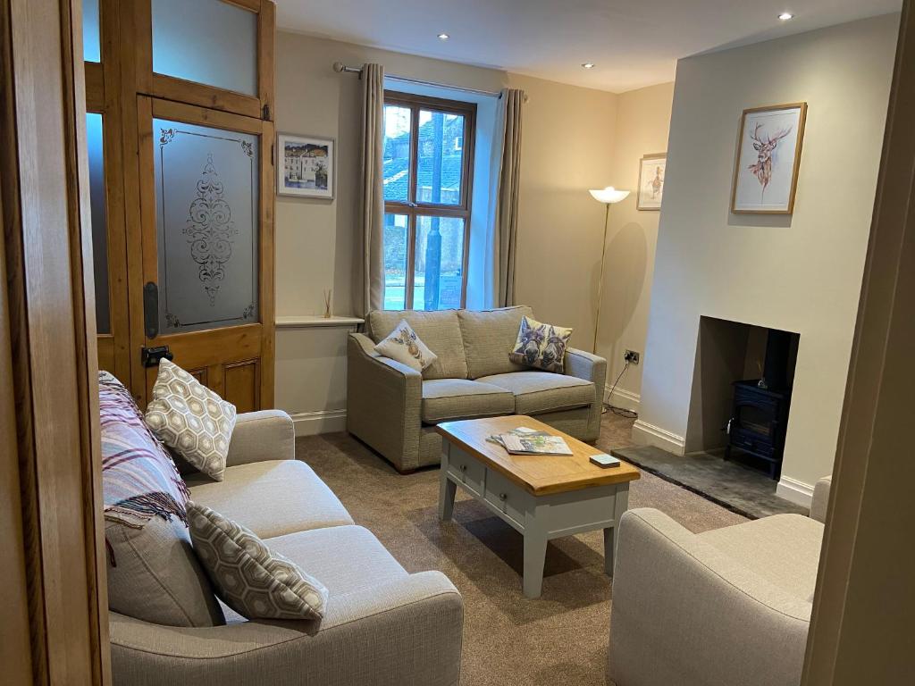 a living room with two couches and a table at Nab View Cottage in Whalley