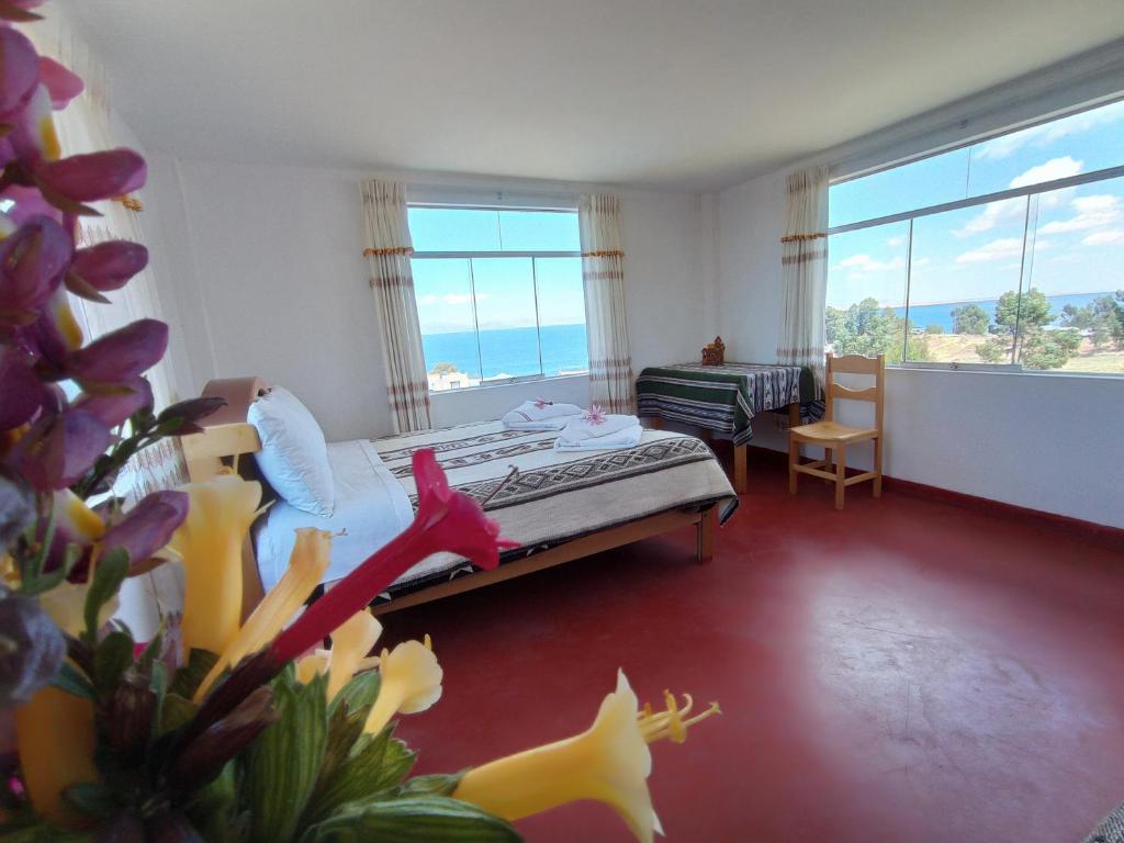 ein Schlafzimmer mit einem Bett und einem großen Fenster in der Unterkunft Hospedaje y Restaurante Saywa in Llachon