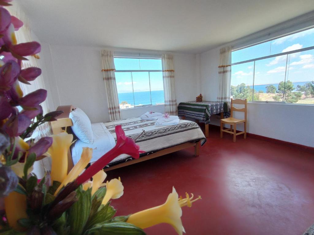a bedroom with a bed and a large window at Hospedaje y Restaurante Saywa in Llachon