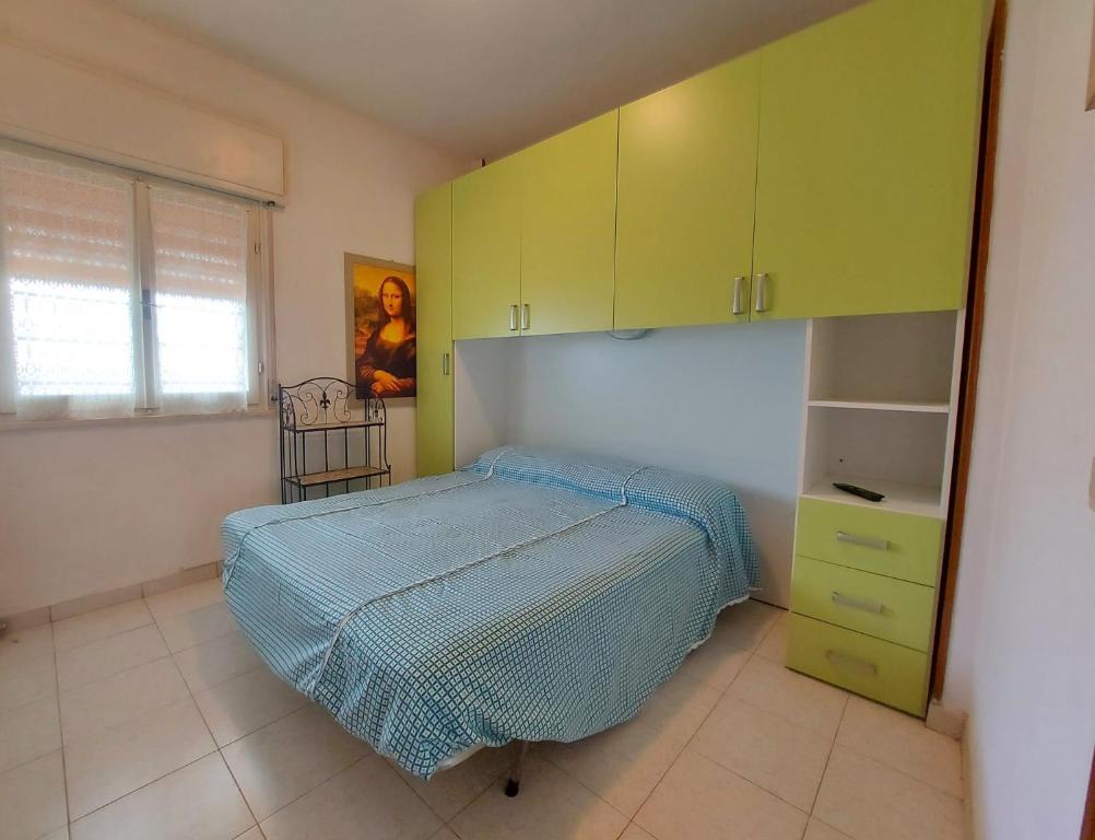 a bedroom with a bed and green cabinets at Pagoda 4 in Lido di Pomposa