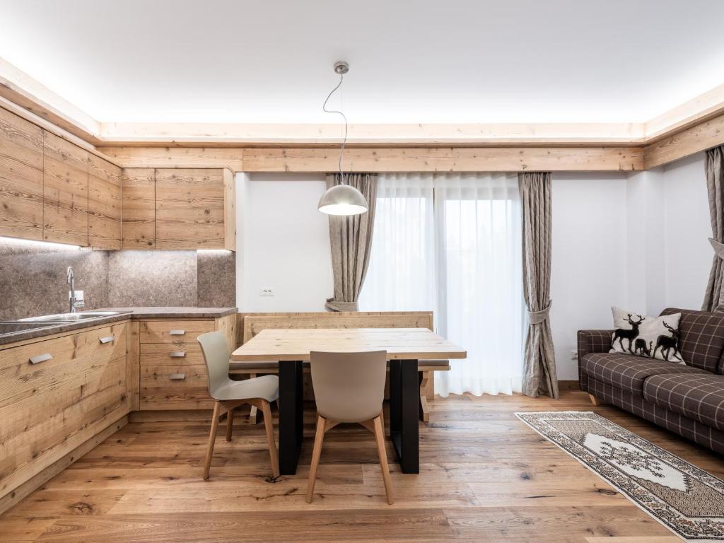 eine Küche und ein Esszimmer mit einem Tisch und Stühlen in der Unterkunft Residence Mairhofer in Toblach