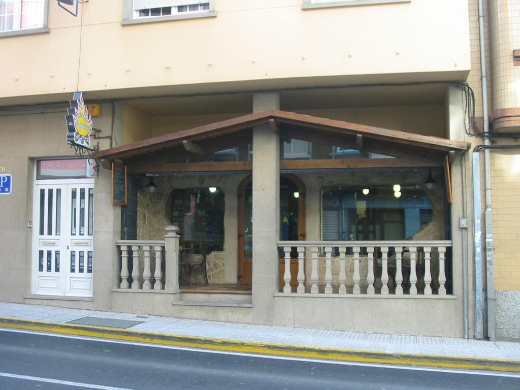 una tienda frente a un edificio con balcón en Pension Vagalume, en Boiro