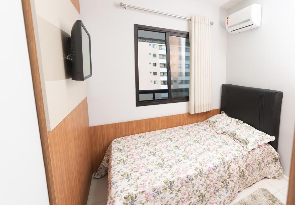 a bedroom with a bed and a window at Apartamento Auto padrão 2 quartos vista mar praia da armação in Salvador