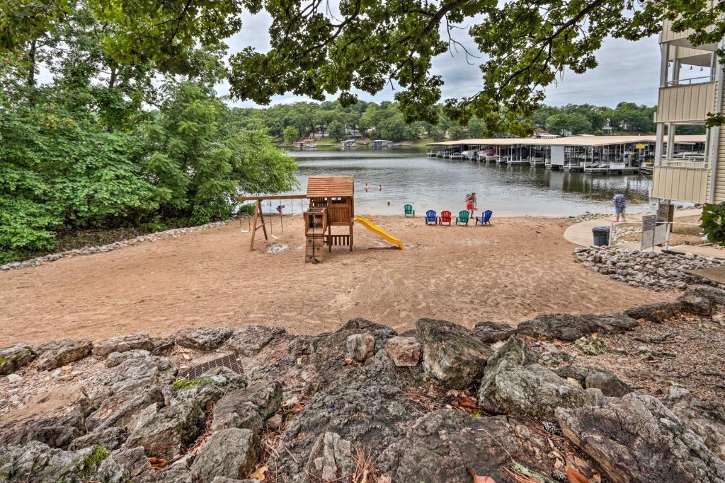 a beach with a playground and people in the water at Lake of the Ozarks Home with Balcony and Grill! in Osage Beach